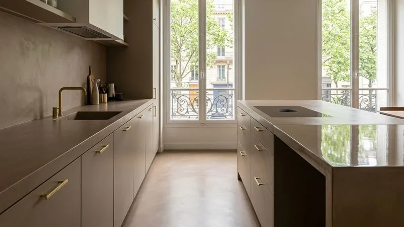 Sol en béton ciré dans une cuisine moderne avec îlot central et plan de travail