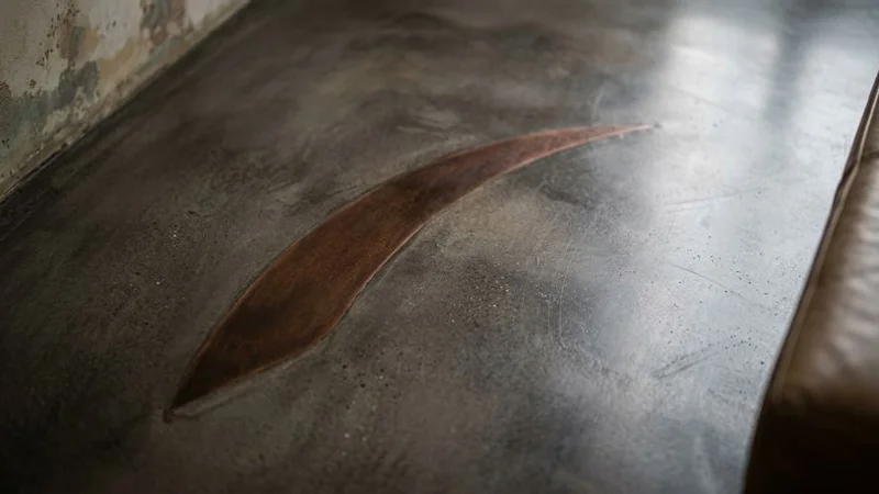 Détail de la texture fine du béton ciré avec reflets satinés